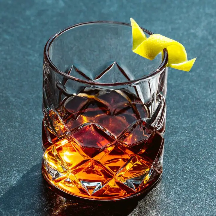 Original Sazerac cocktail in a crystal-cut glass with a lemon twist garnish