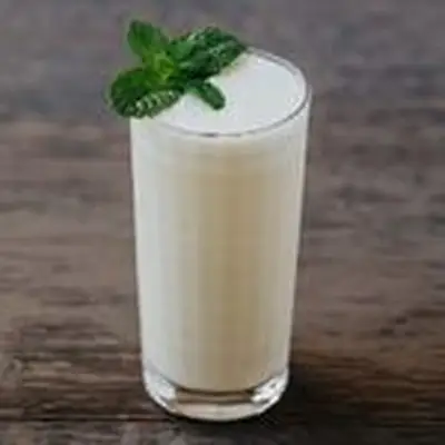 white-colored Absinthe Suisse cocktail in a collins glass, garnished with a mint sprig