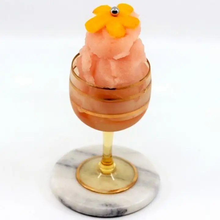 Negroni Sorbet in an amber-colored wine glass garnished with an orange peel flower