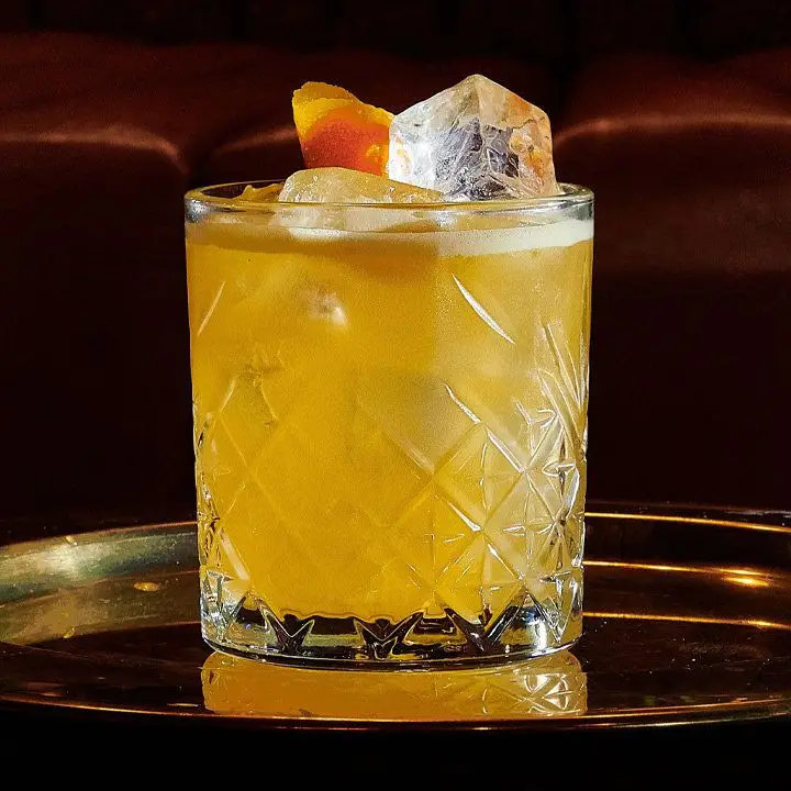 Definite Maybe cocktail in a crystal-cut rocks glass on a round tray