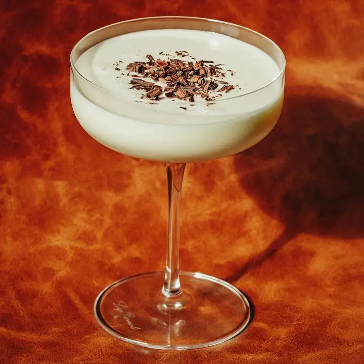 Golden Cadillac cocktail in a coupe glass, garnished with chocolate shavings
