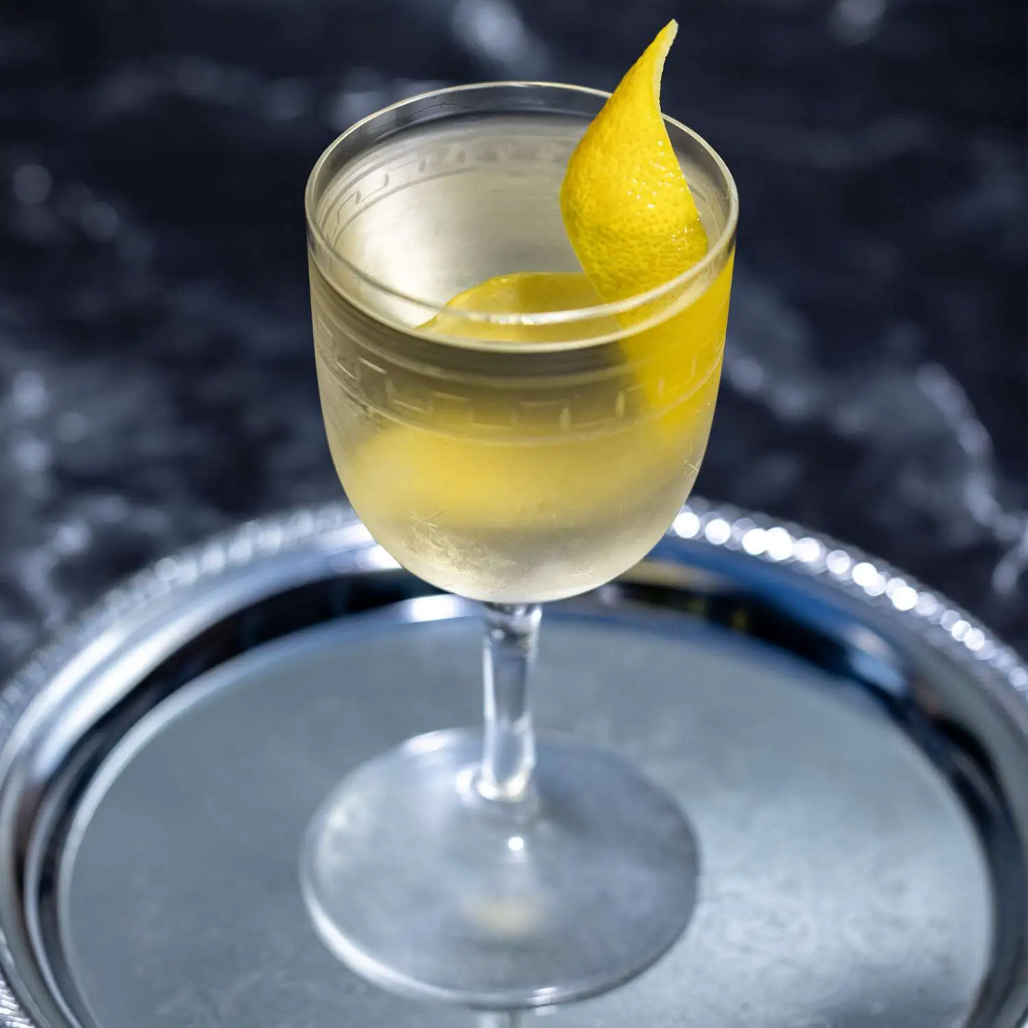 Smoky Martini with a lemon twist served on a metal tray