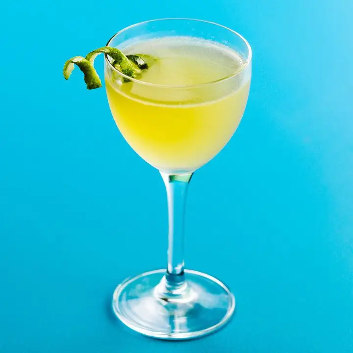 The Bonpland cocktail with a lime twist, served on a bright blue backdrop