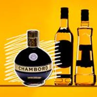 A squat, round bottle of Chambord, its name prominently printed on its golden label, sits on a yellow background with white squiggles directly behind. Next to it are the outlines of other bottles, their labels darkened. 