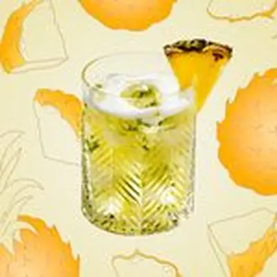 Pineapple Caipirinha cocktail in rocks glass with pineapple wedge garnish, with illustrated background of pineapples