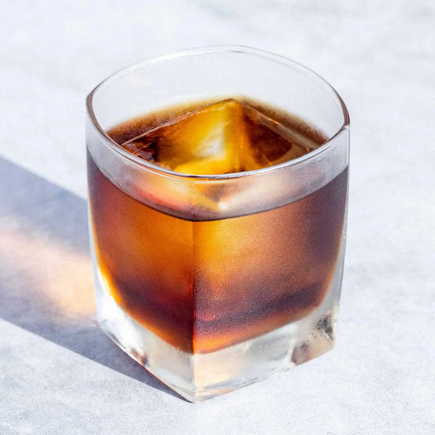 Black Russian cocktail in rocks glass with single large ice cube