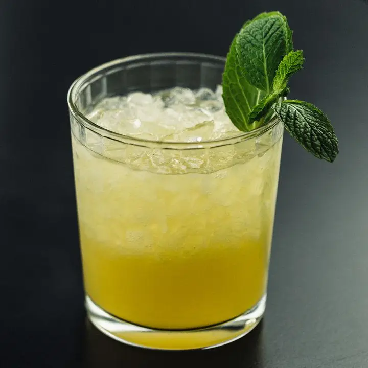 A yellow-hued Mai Tai on crushed ice garnished with a mint sprig