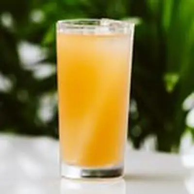 1928 Sea Breeze cocktail on white surface with green background