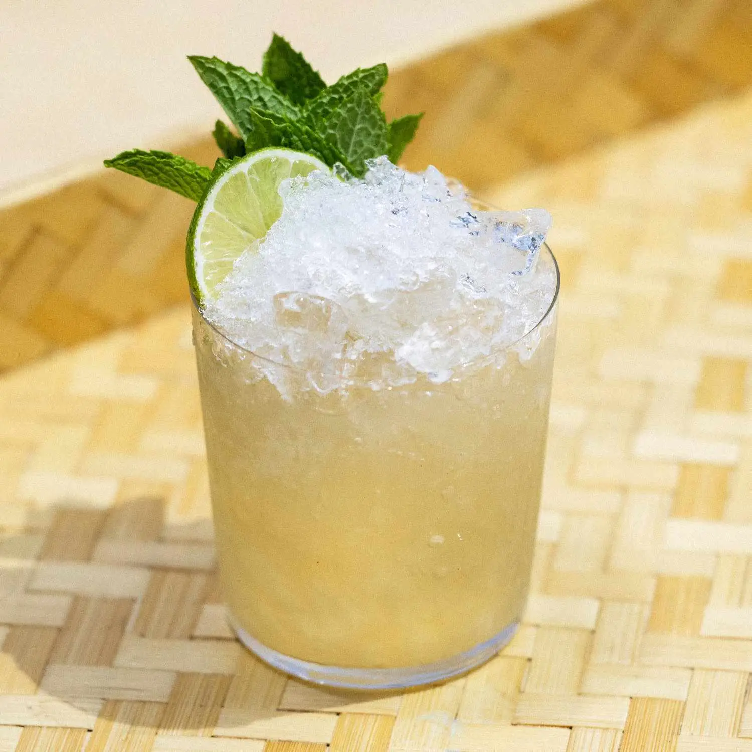 Tia Mia cocktail served in a rocks glass with crushed ice and a lime wheel and mint garnish