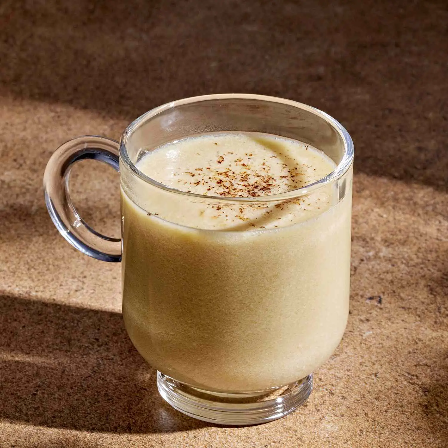 Posset in clear, footed coffee mug with spice dusting on top