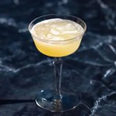 Corpse Reviver No 2 cocktail in coupe glass, shot against black marble backdrop