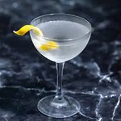 Vesper Martini with lemon twist in a coupe glass on dark marble background