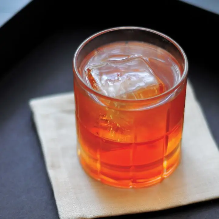 Monte Carlo cocktail in a rocks glass over one large ice cube, served on a white napkin