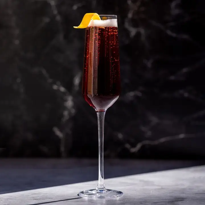 Kir Royale cocktail in champagne flute with lemon twist garnish