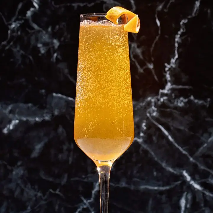 golden Magic Hour cocktail in a flute with a grapefruit twist
