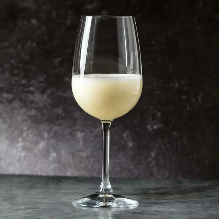 icy Sgroppino cocktail in a white wine glass set on a stone surface