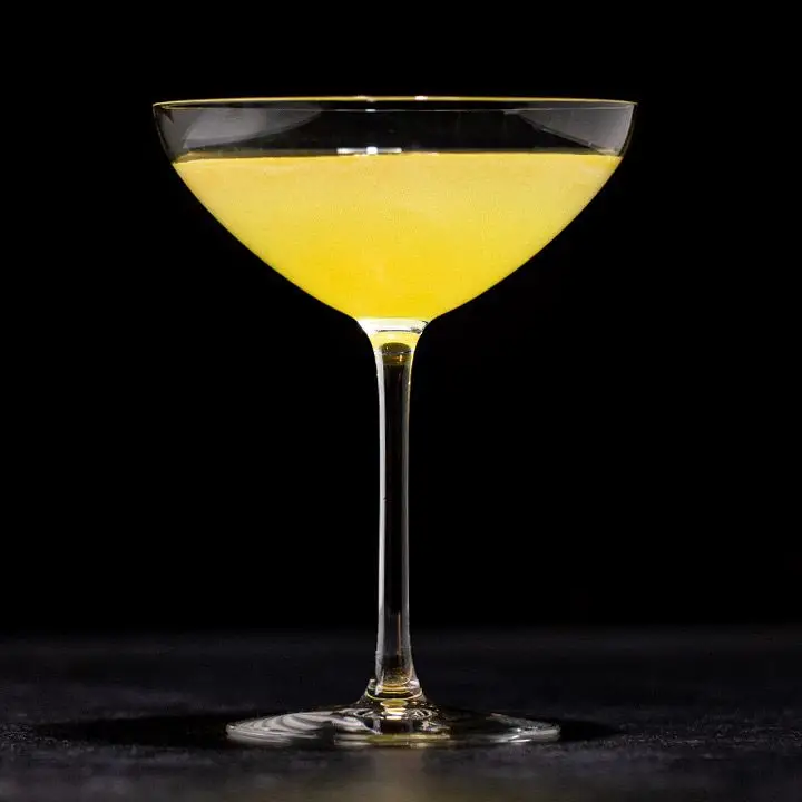 bright-yellow Flying Dutchman cocktail set against a dark background