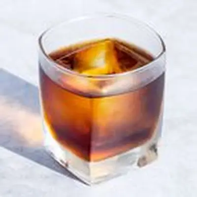 Black Russian cocktail in rocks glass with single large ice cube