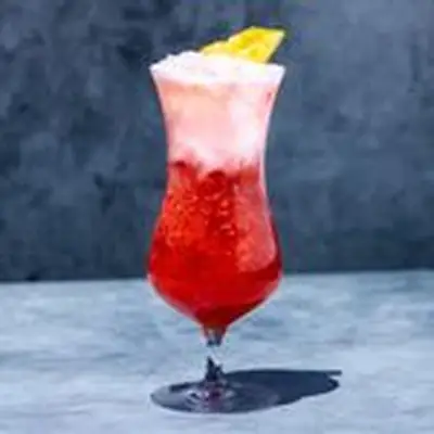 Miami Vice cocktail in curved Hurricane Glass, with white Pina Colada layer floating on top of red Strawberry Daiquiri layer, and pineapple wedge garnish