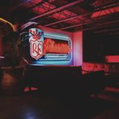 Interior of Refuge in Houston, Texas, showing leather couches and replica Floridita neon sign