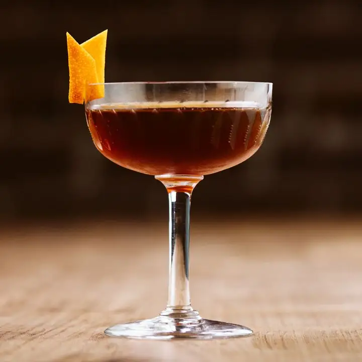 Revolver cocktail in a coupe glass with an orange peel garnish