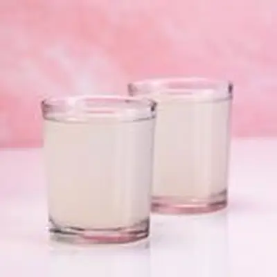 Two pale green Kamikaze drinks in shot glasses, on light pink background