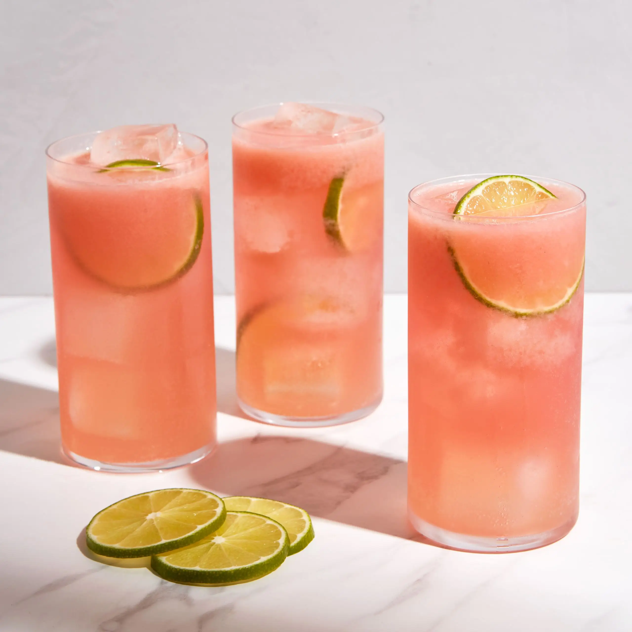 Three tall cocktails made with tequila mezcal raspberry syrup and ginger beer.