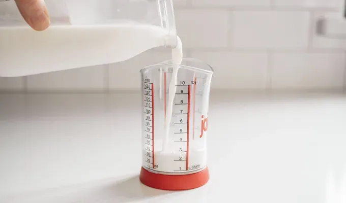 Pouring milk into a small measuring cup.' title='Sweet Cream Cold Foam Recipe