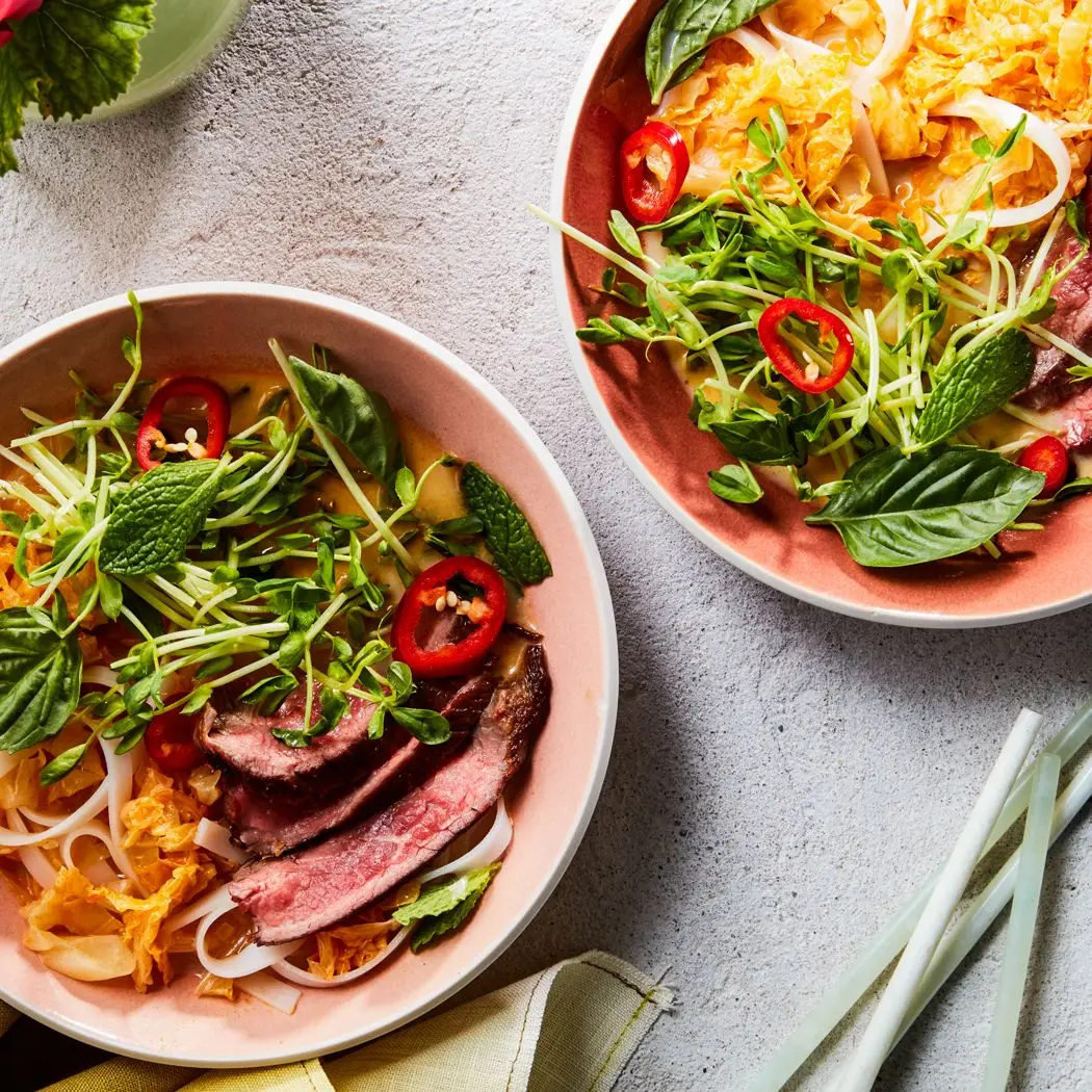 Tigelas de macarrão de curry vermelho com bife e repolho