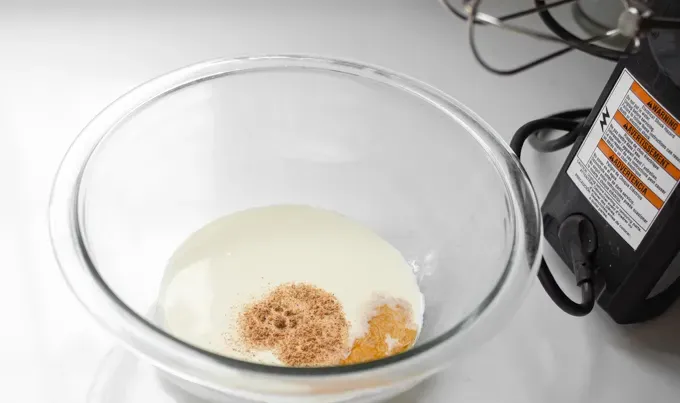 Placing the ingredients for the nutmeg whipped cream in a mixing bowl.' title='Easy Baked Pumpkin Custard with Nutmeg Whipped Cream