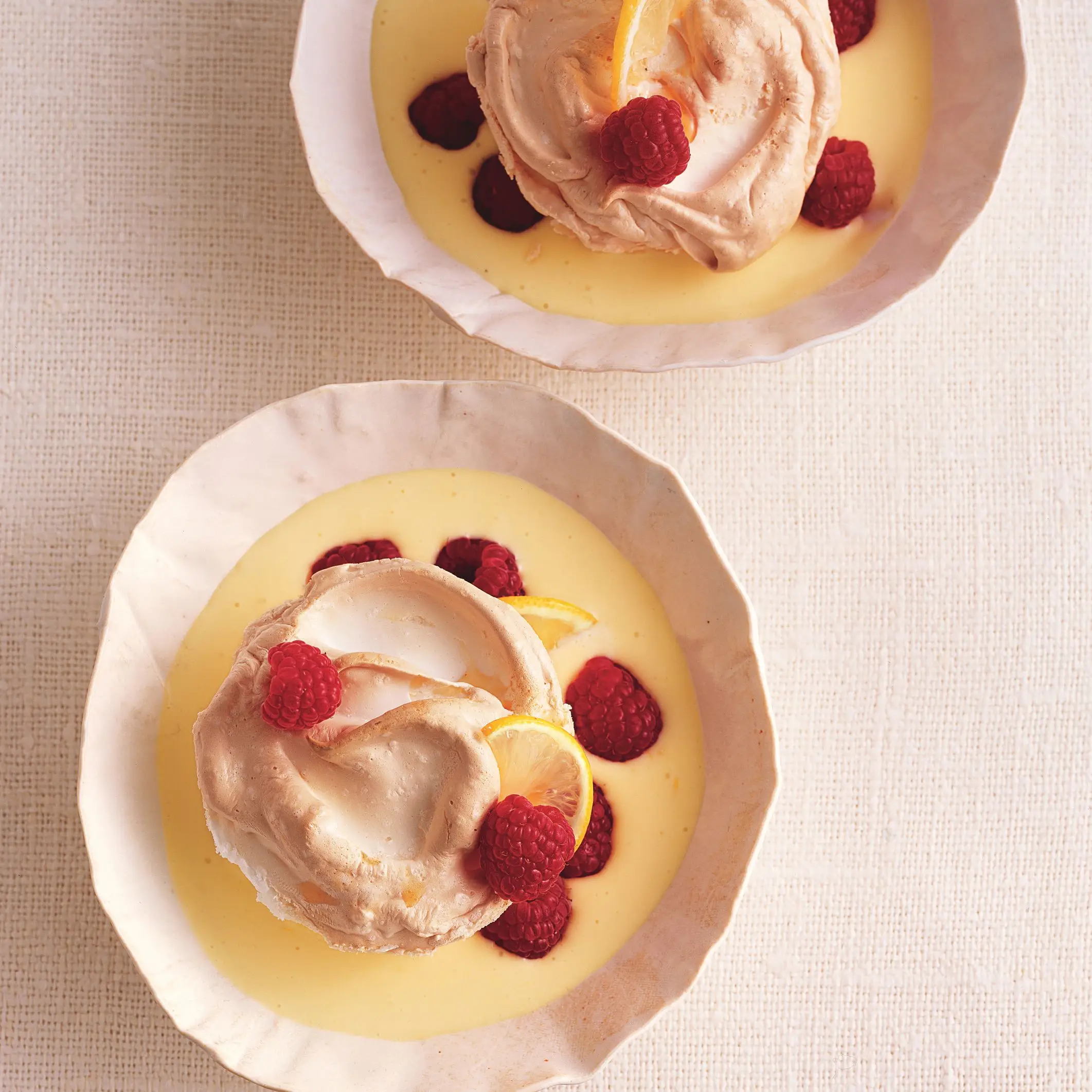 Ilhas flutuantes com molho de creme com aroma de limão e framboesas