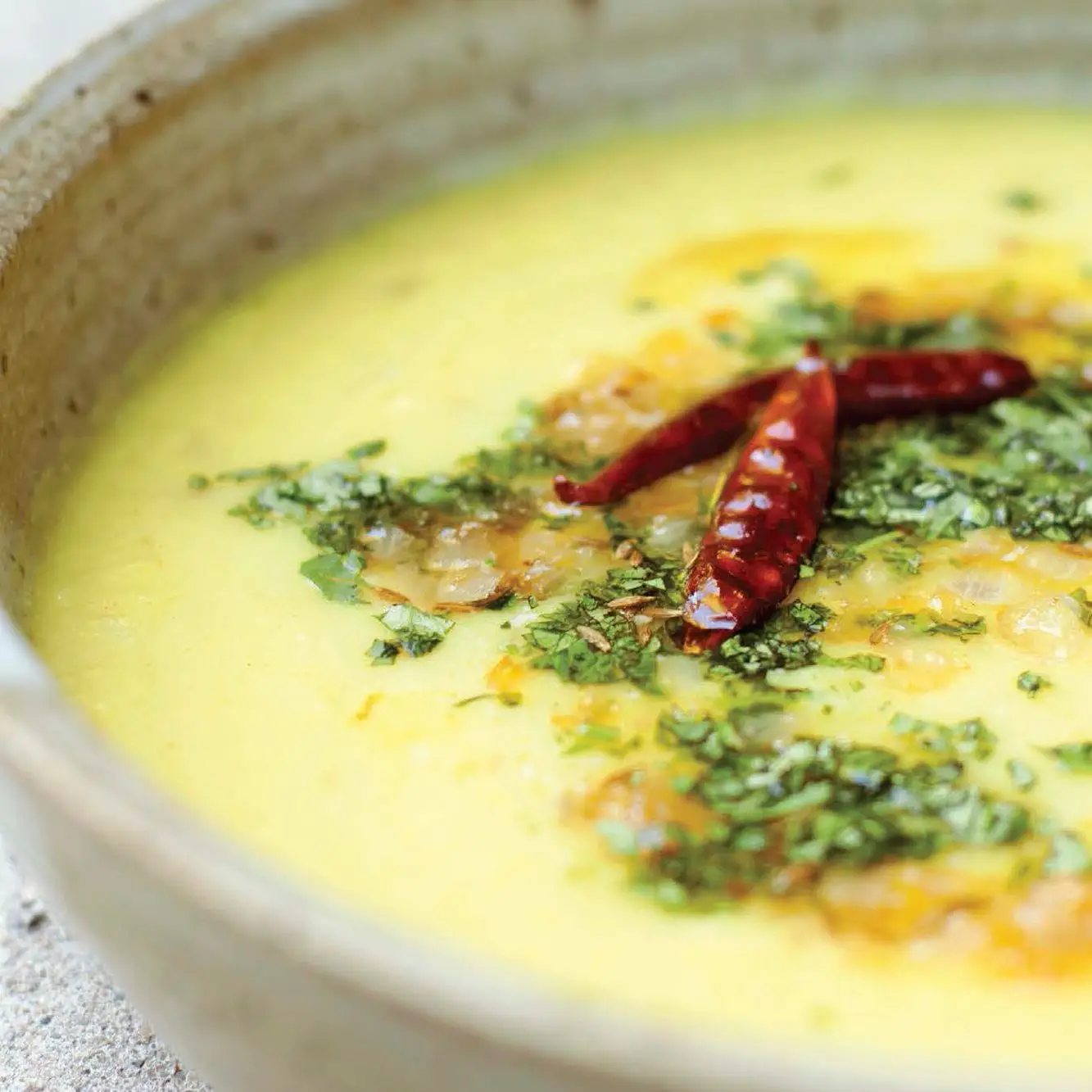 A closeup shot of yellow dal in a bowl.