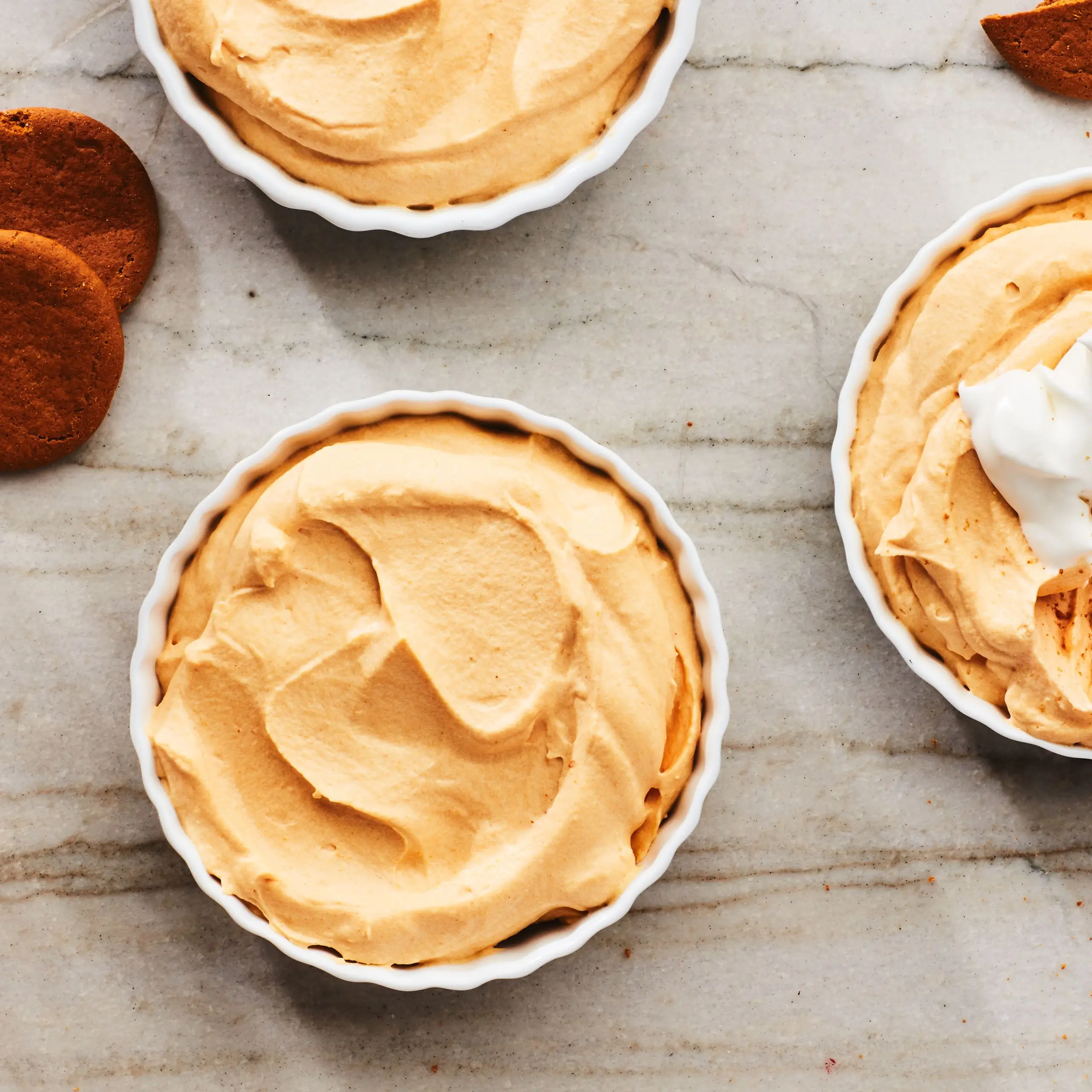 Pumpkin puree recipes Top view of white chocolate pumpkin mousse in ramekins.