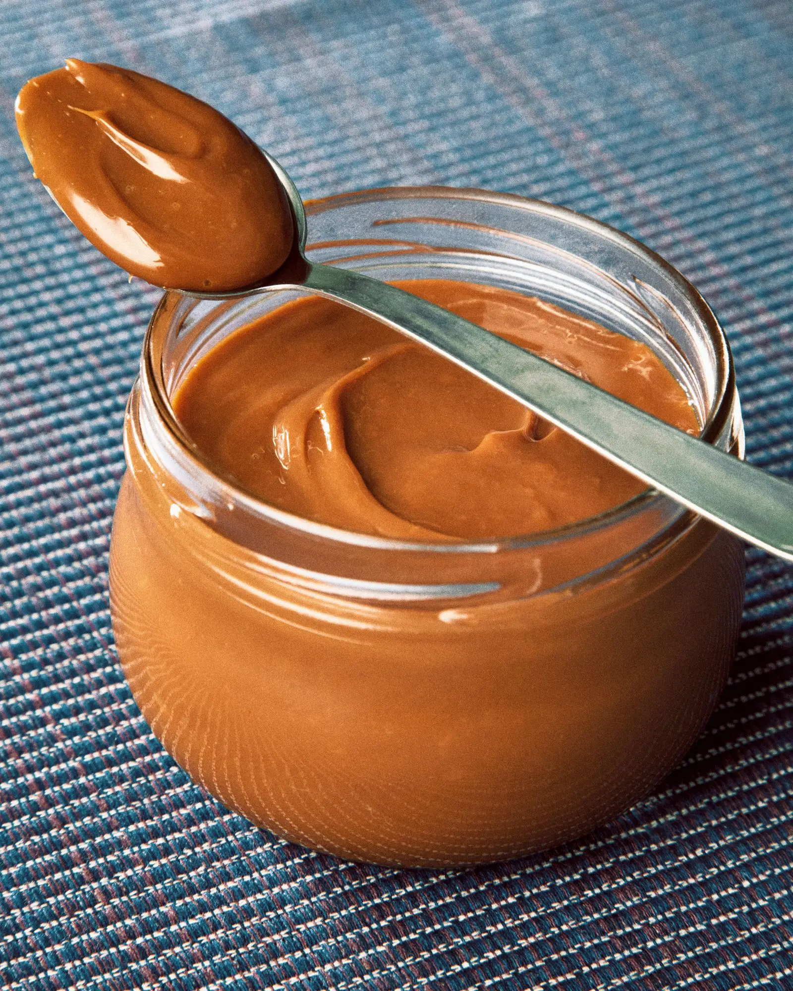 Dulce de leche in a jar and spoon.