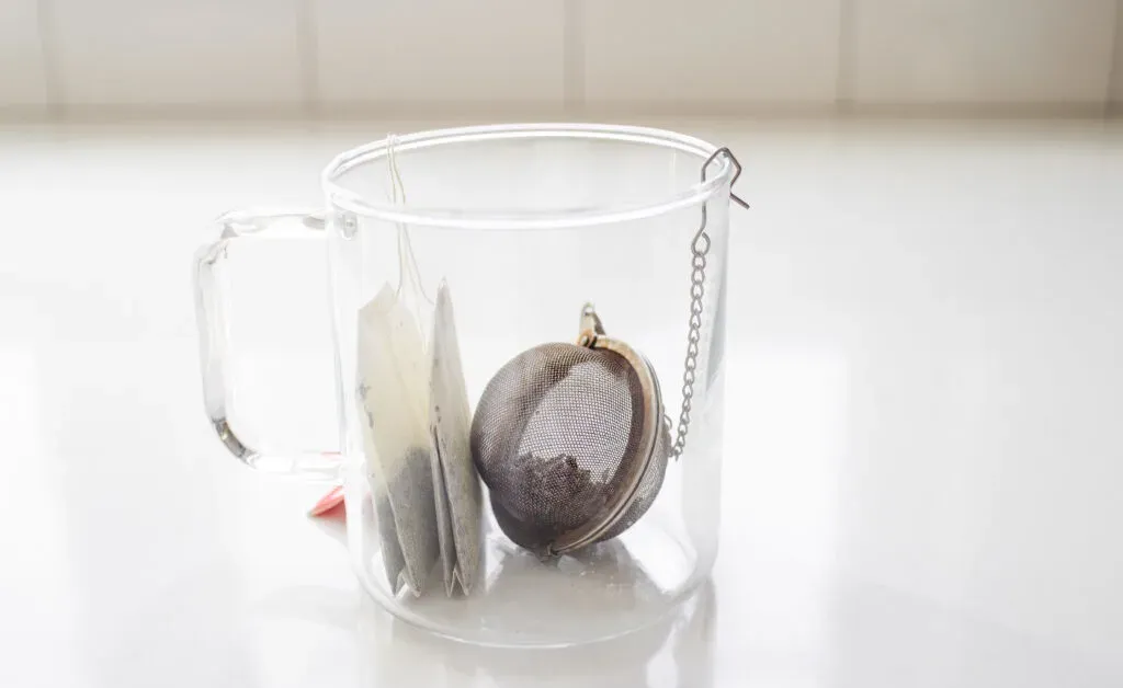 Placing the tea bags and strainer in a mug to make the London Fog latte.' title='Homemade London Fog Tea Latte (Earl Grey Latte)