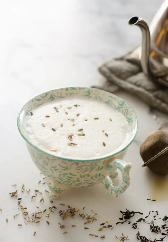 A London Fog Tea Latte (AKA Earl Grey Latte) in a pretty teacup with a tea kettle behind it. ' title='Homemade London Fog Tea Latte (Earl Grey Latte)