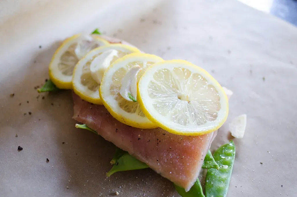 Placing all of the ingredients on a sheet of parchment paper to make salmon en papillote.' title='Salmon en Papillote
