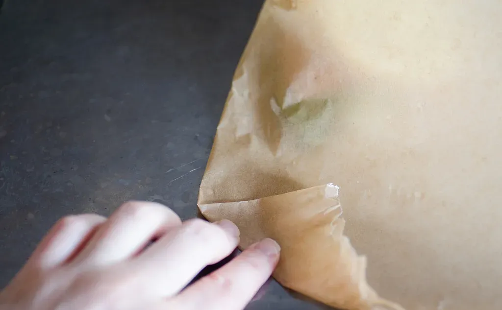 Starting to fold the piece of parchment paper up.' title='Salmon en Papillote