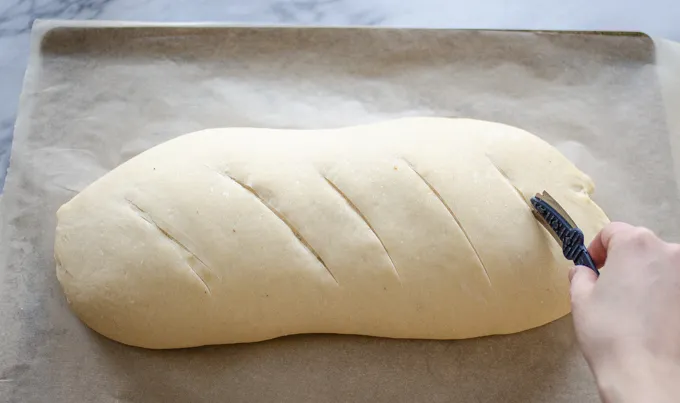 Scoring the soft sourdough French bread with a baker’s lame. ' title='Soft Sourdough French Bread Without Yeast!