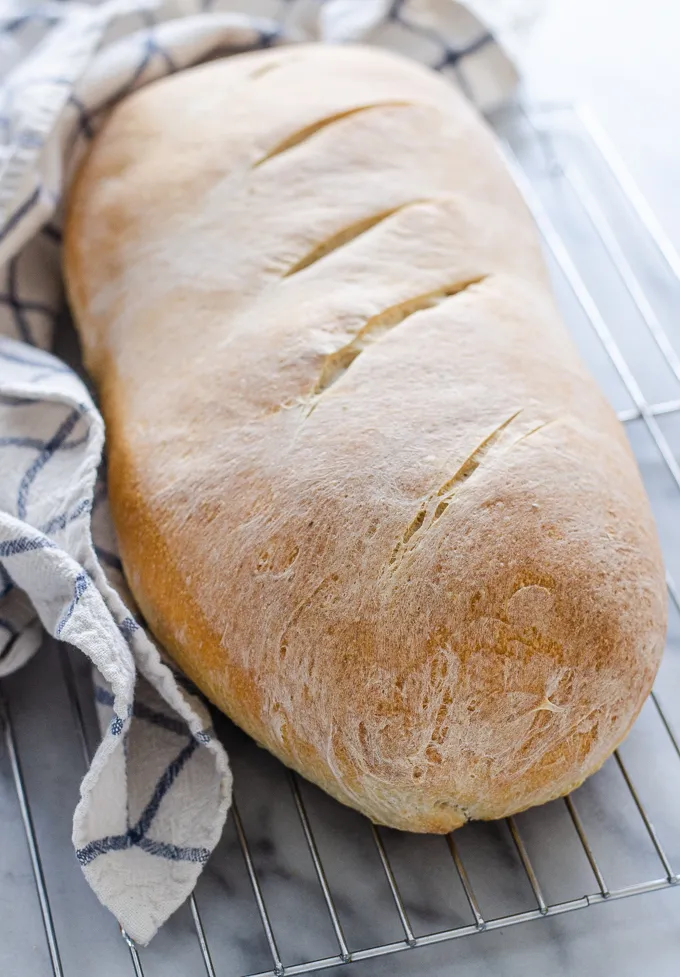 A loaf of Soft Sourdough French Bread No Yeast all baked and on a cooling rack.' title='Soft Sourdough French Bread Without Yeast!