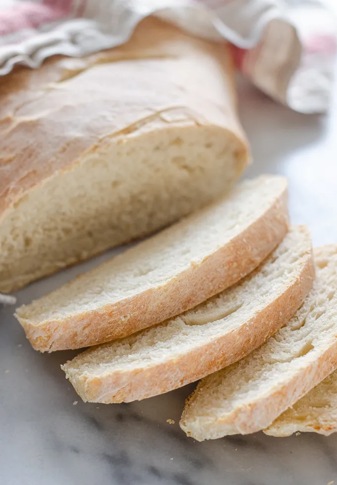 A sliced loaf of Soft Sourdough French Bread No Yeast on a marble surface.' title='Soft Sourdough French Bread Without Yeast!