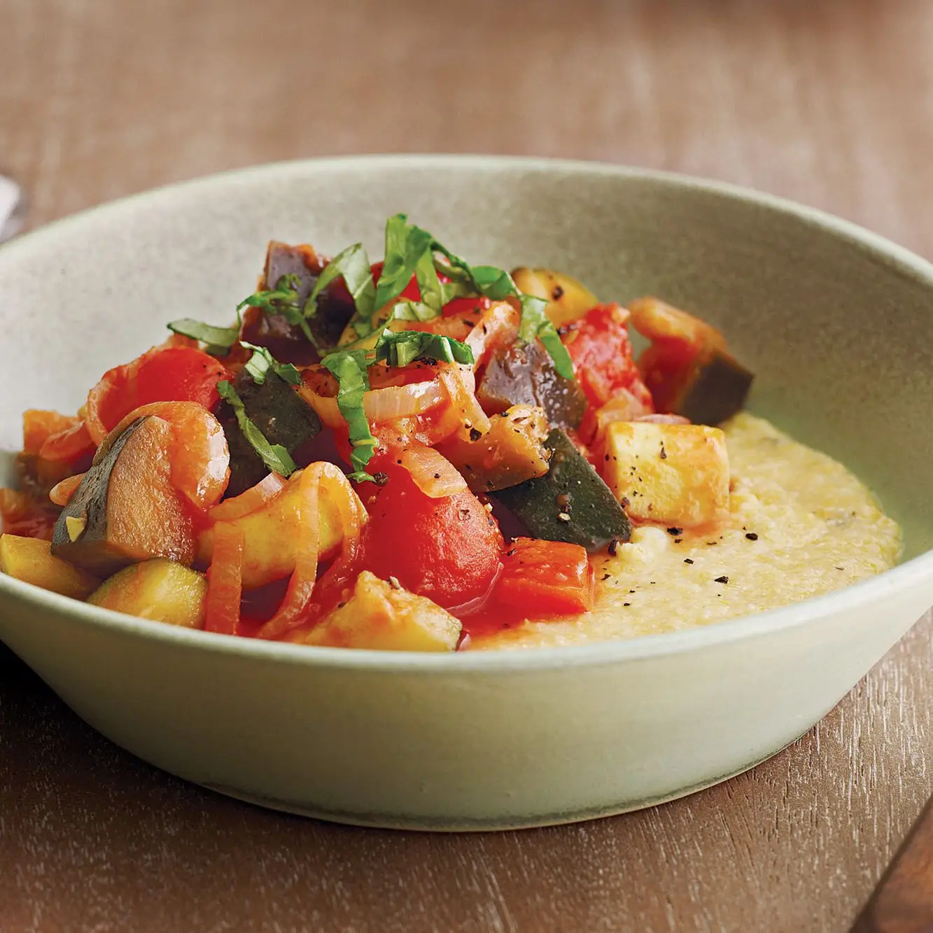 Ratatouille cozido lento sobre o queijo de cabra polenta