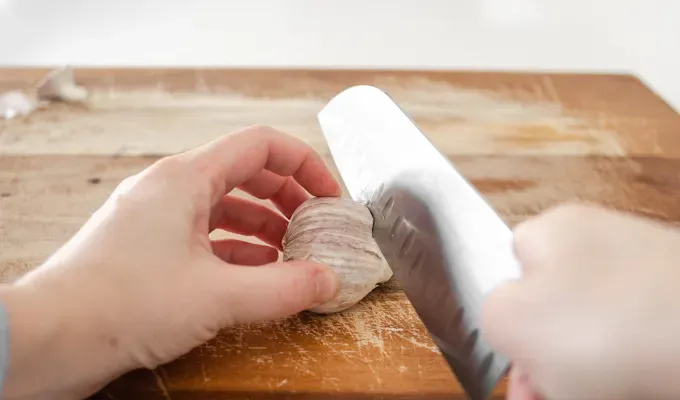 Slicing the top off a head of garlic.' title='How to Roast Garlic Without Aluminum Foil