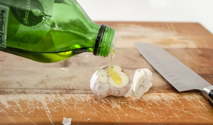 Drizzling olive oil on top.' title='How to Roast Garlic Without Aluminum Foil