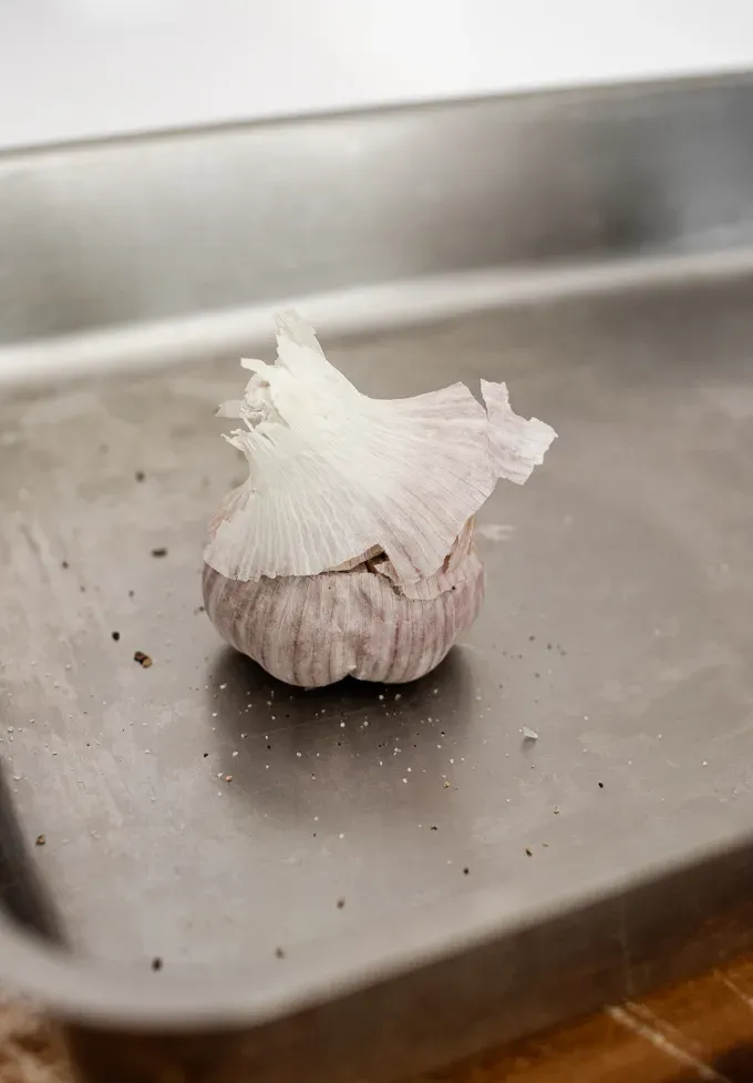 A head of garlic on a baking pan.' title='How to Roast Garlic Without Aluminum Foil