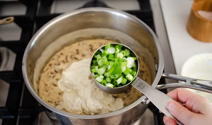 Adding the chopped green onions to the soup base.' title='Gluten Free Cheesy Potatoes