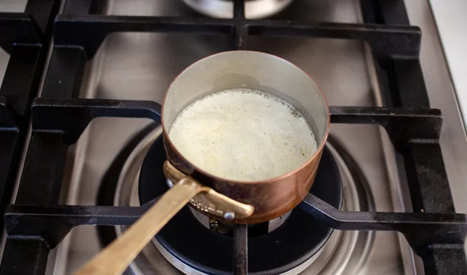 Melting the butter in a copper pot.' title='Gluten Free Cheesy Potatoes