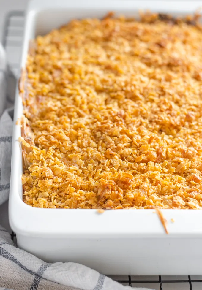 The baked gluten free cheesy potatoes (AKA funeral potatoes) in a white casserole dish on top of a wire cooling rack.' title='Gluten Free Cheesy Potatoes