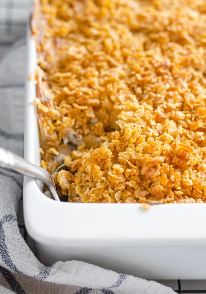 The baked gluten free cheesy potatoes (AKA funeral potatoes) in a white casserole dish on top of a wire cooling rack.' title='Gluten Free Cheesy Potatoes
