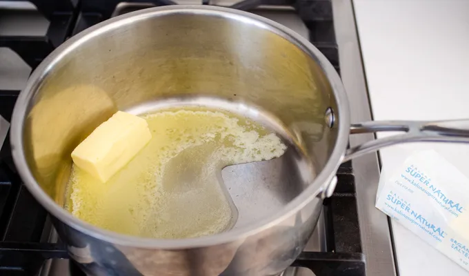 Melting the Kalona SuperNatural butter in a stainless steel pot.' title='Gluten Free Cheesy Potatoes